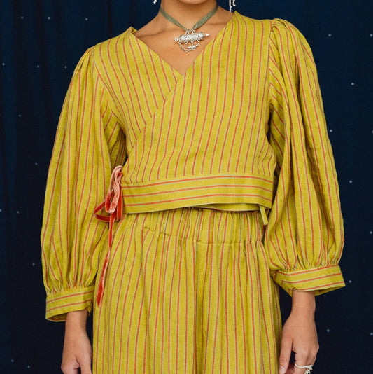 woman wearing a striped lime green wrap top on a navy blue background