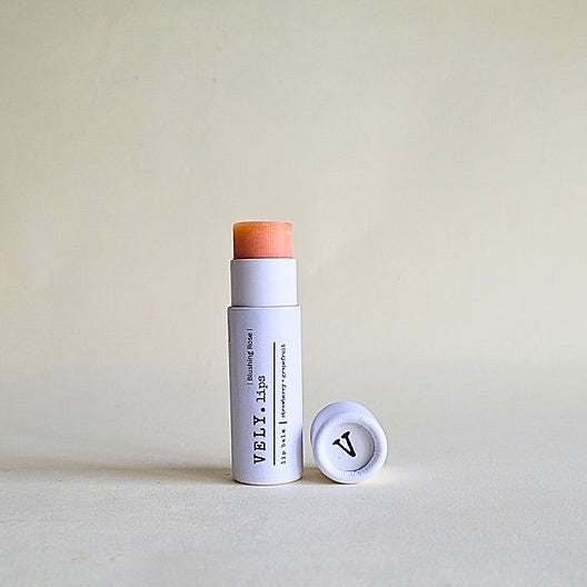 Lip Balm stick with a white casing and brown top on a light gray background