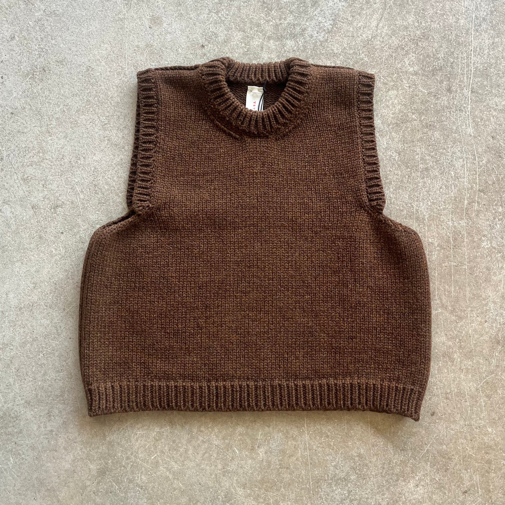 A brown knitted vest on a beige background 