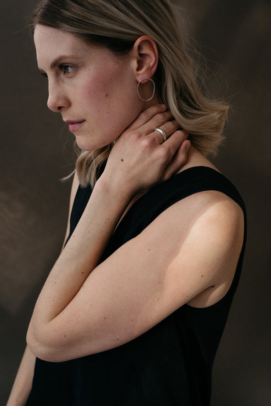 A pair of sterling silver oval earrings worn by a model