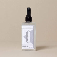 Load image into Gallery viewer,  A clear bottle with a black spray pump labeled &#39;Garment Refresher&#39; by Norfolk Natural Living, with Coastal Walks scent mentioned on the label.
